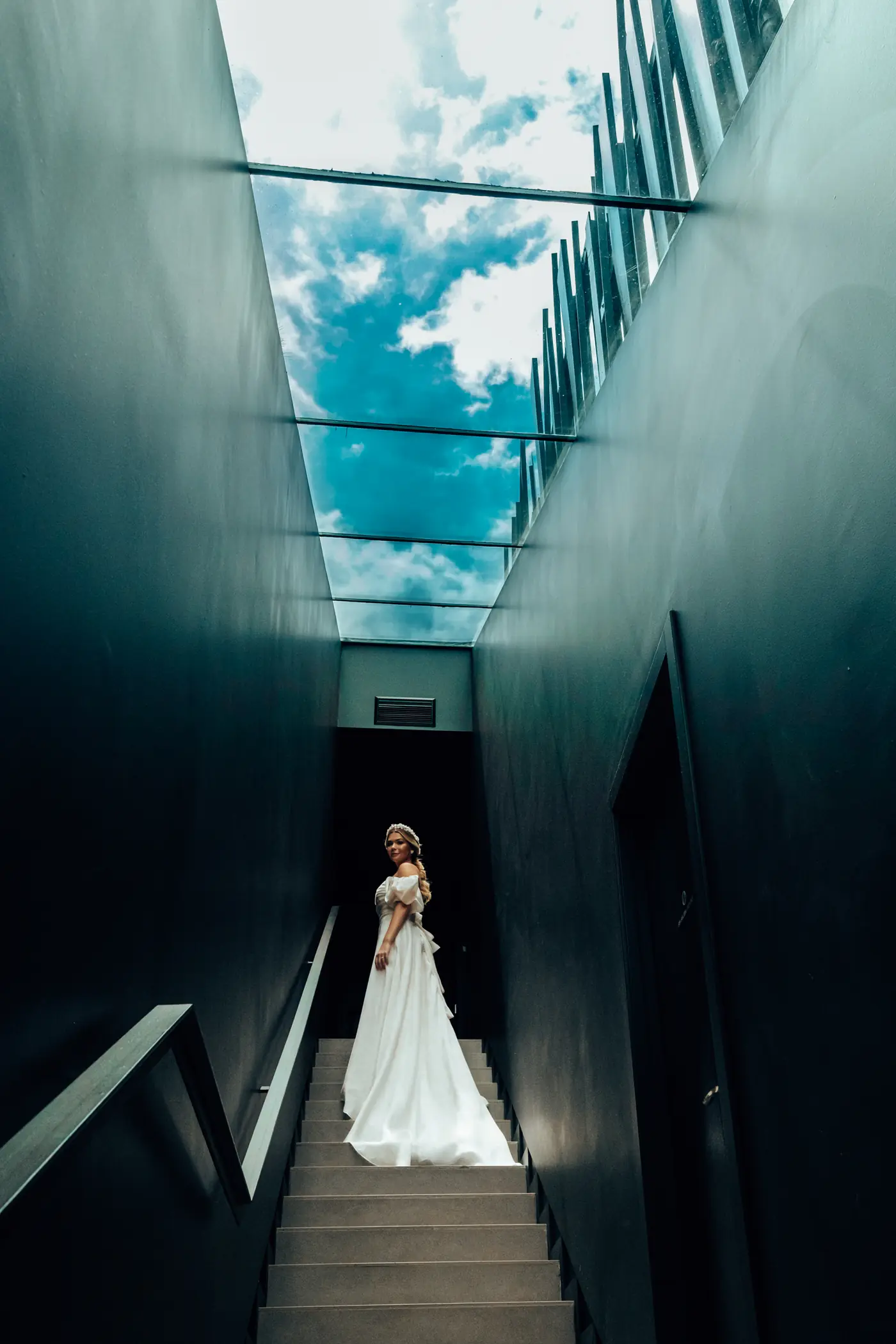 Novia bajando unas escaleras con la cola del vestido extendida