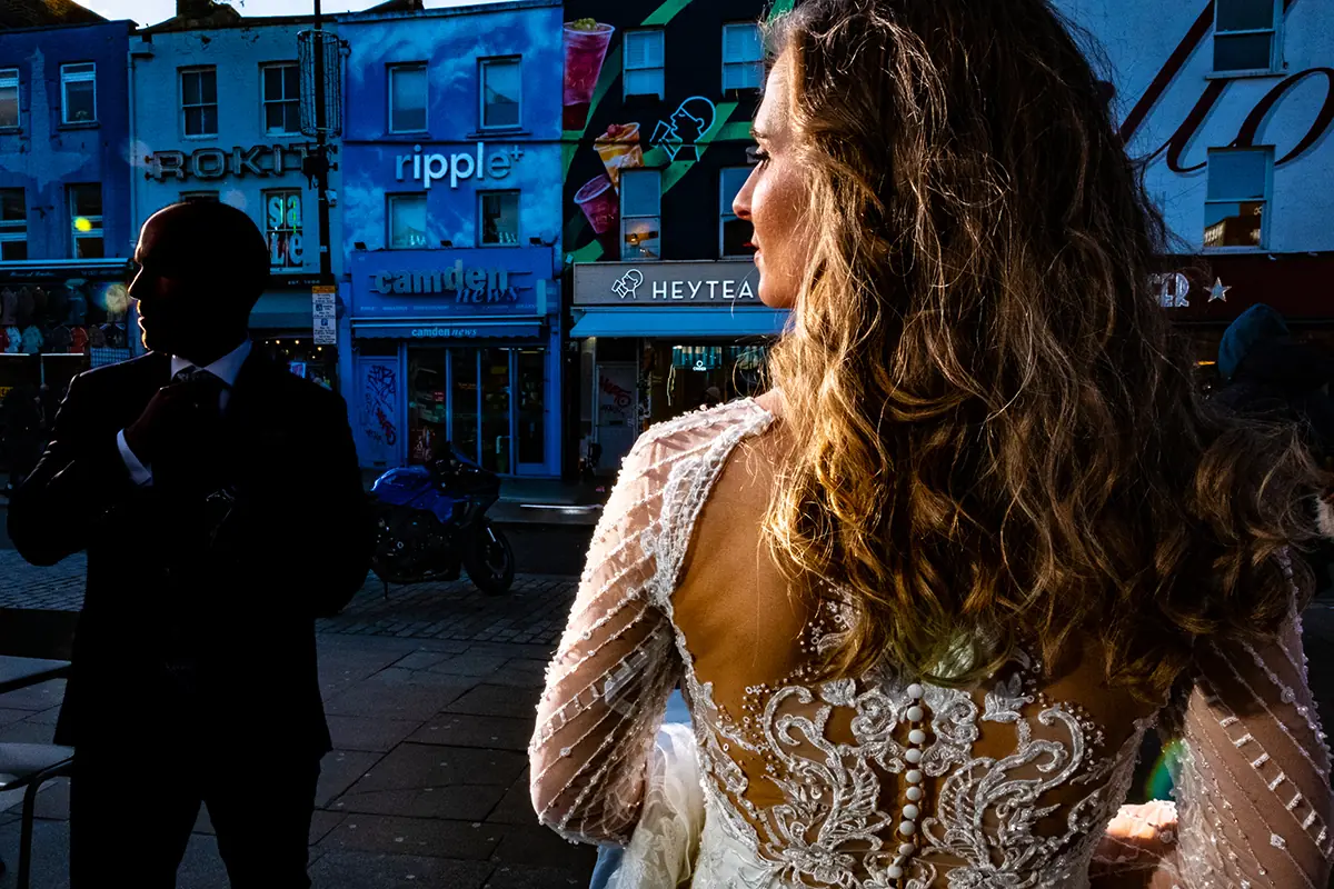 Novia caminando por una calle con fachadas azules
